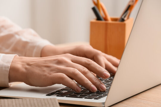 Young female programmer working with laptop in office, closeup
