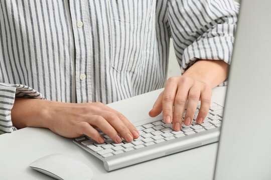 Young female programmer with computer typing on keyboard in office, closeup