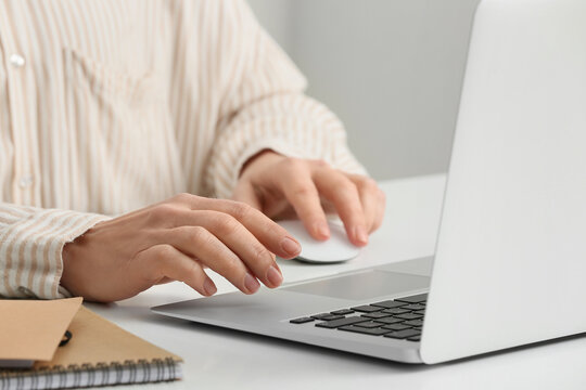 Young female programmer with laptop and notebooks working in office, closeup