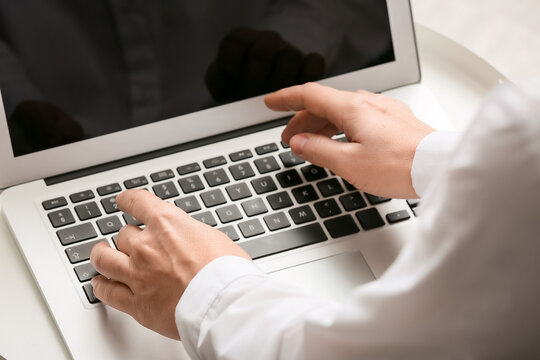 Young female programmer with laptop working in office, closeup