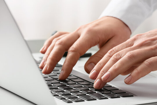 Young female programmer with laptop working in office, closeup