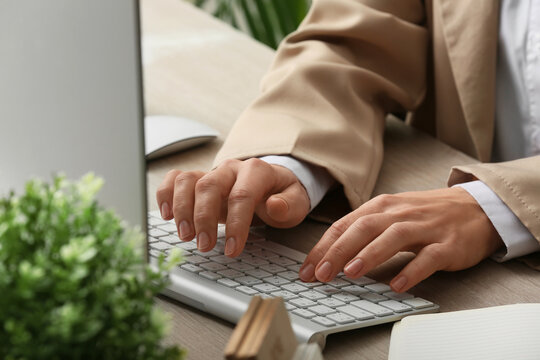 Young female programmer with computer typing on keyboard in office, closeup