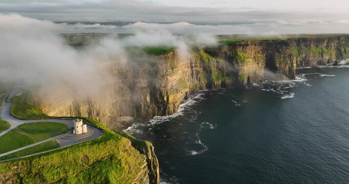 Aerial view of Cliffs of Moher and OBrien Tower at sunrise with sea mist over Atlantic Ocean County Clare Ireland