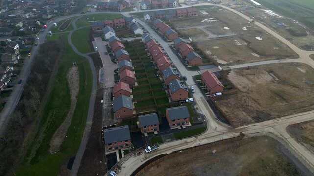 New homes under construction in a suburban area near a city at sunset at Taylor Wimpey, Ripon, UK.