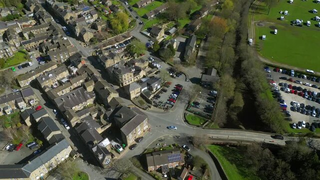 Exploring a small town from above with houses, roads, and open fields during sunny weather at Pateley Bridge village, UK.