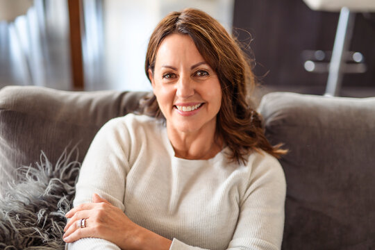 Beautiful aging. Portrait pretty mature female pensioner sit on sofa
