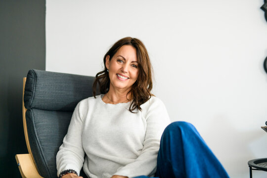 Beautiful aging. Portrait pretty mature female pensioner sit on sofa