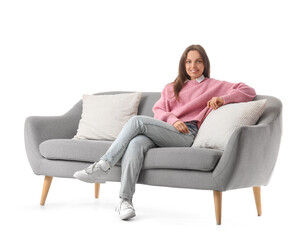 Obraz premium Young woman sitting on grey couch against white background