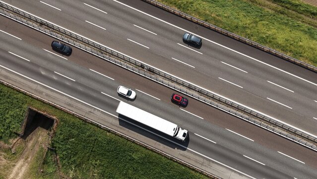 Fast cars and heavy traffic in motion drive along the urban highway lanes of a busy city freeway asphalt road