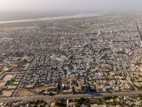 Aerial view of the dense urban sprawl and residential rooftops with the Indus River in the background in Hyderabad, Sindh, Pakistan.