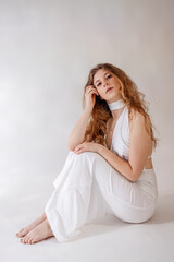 Fototapeta premium Stunning portrait of a beautiful young woman with long voluminous curly hair posing in a professional photo studio, beauty and fashion concept, Prague, Czech Republic, June 2025