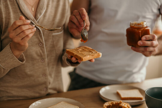 Couple preparing breakfast with peanut butter and jelly