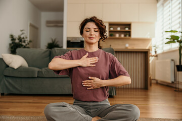 Woman meditating at home practicing breathing exercises