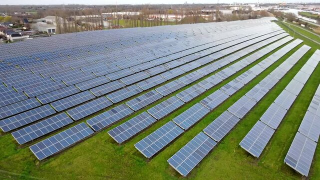 Aerial drone pan across industrial solar farm in operation