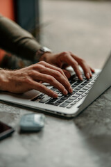 Hands typing on laptop keyboard working remotely