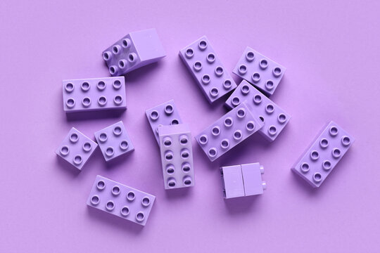 Plastic building blocks on purple background