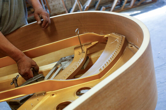 Worker assembling piano interior frame