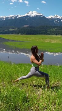Vertical video: Starting she flowing lunge to crescent, stretching at pond, sports bra, leggings