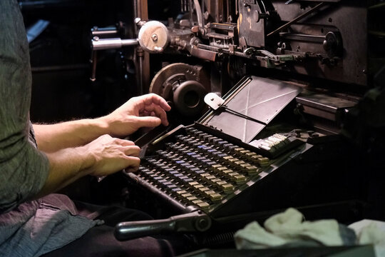 Operator using vintage typesetting machine