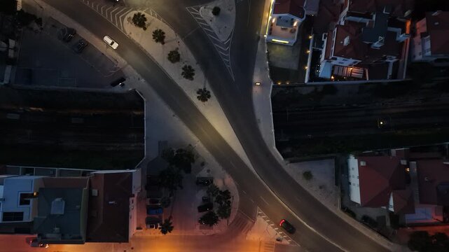 Aerial view of cars driving on illuminated streets at night with residential houses in Estoril, Lisbon, Portugal.