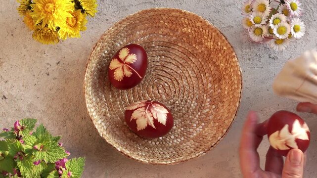 Smearing handmade Easter egg dyed with onion peels with lard for shine and putting into basket