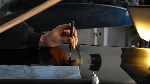 4k video PDR technician uses a precision knockdown punch and a wooden hammer to level metal high spots.
