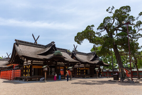 Traditioneller japanischer Shinto-Schrein mit geschwungenem Dach und rotem Zaun unter bew&ouml;lktem Himmel
