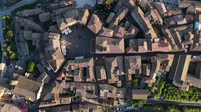 Aerial view of the historic stone buildings, terracotta rooftops and central circular piazza in the medieval town of Montefalco, Umbria, Italy.