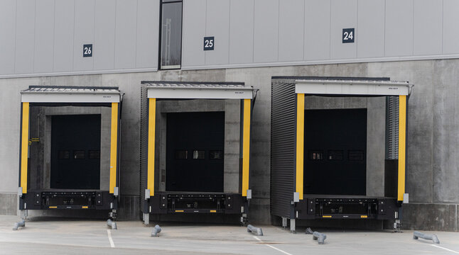 Warehouse loading docks with protective gates in industrial area.