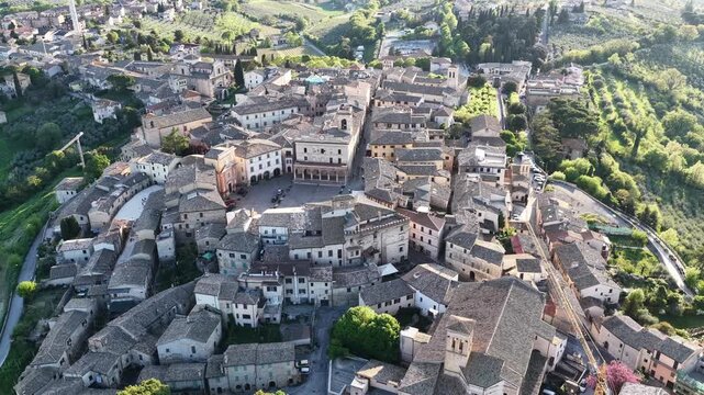 Aerial view of the historic hilltop town of Montefalco with its central square, stone buildings, and surrounding green hills in Montefalco, Umbria, Italy.