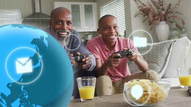 Father and son pressing controllers, starting gaming UI globe and icons overlaying pads, bonding