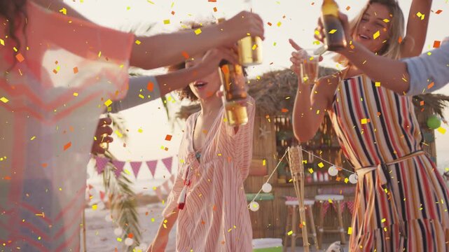 Vertical video: Arms joining urging lead woman pink dress lifting bottle on beach cheering confetti
