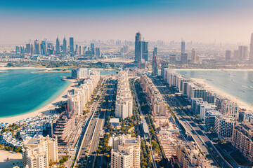 Obraz premium Dubai cityscape featuring the iconic Palm Jumeirah island, luxury resorts, and urban skyline with Persian Gulf waters
