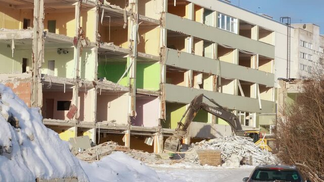 Narva, Estonia &ndash; March 2026: Excavator demolishing residential building during urban redevelopment in winter