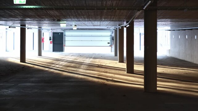 Underground parking garage entrance gate opening with sunlight inside