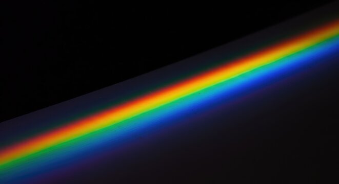 Abstract light refraction background featuring vivid rainbow spectral colors cast onto a smooth surface with sharp focus and gradient, minimal, pattern, color