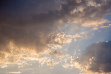 Fototapeta premium Dramatic Sunset Sky With Golden Sun Rays Breaking Through Dark Storm Clouds