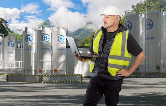 Hydrogen production, Energy site inspection. Engineer with laptop monitors storage tanks and reviews operations at a clean hydrogen facility.