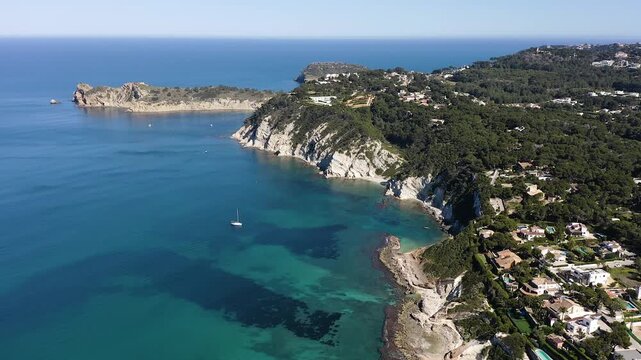 Aerial view of San Martin Cape, with the islet and beach of Portichol, in the Mediterranean coast of Javea, Alicante, Spain.