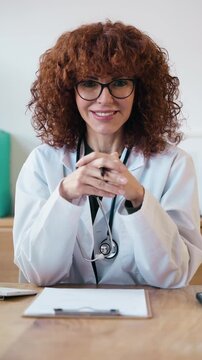 Video of beautiful nutritionist looking at camera while working on computer in the consultation