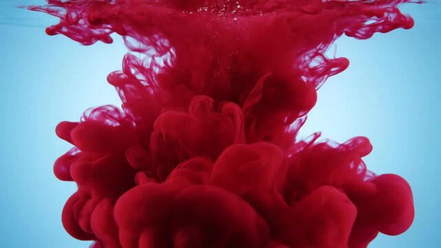 Red ink swirling in water, abstract liquid background, vibrant crimson cloud dispersing in clear liquid