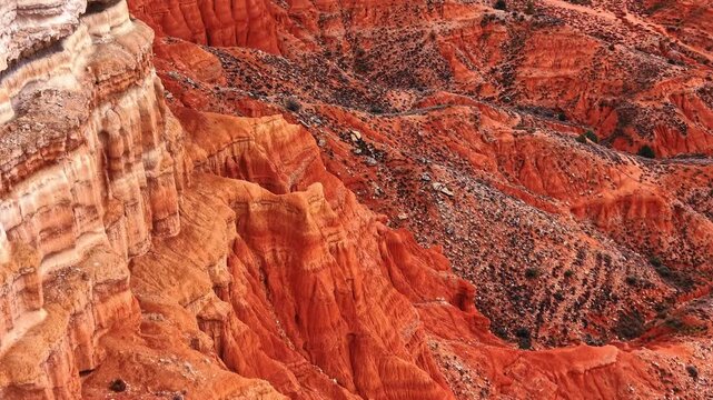 Detail of layered red and white sedimentary rock cliffs. Close-up of eroded clay formations showing geological strata and textures in Aragon Spain.