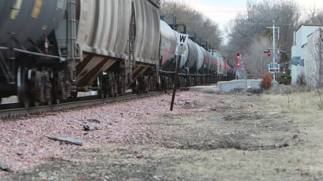 A long freight train with endless cars going down the rails and disappearing into the vanishing point.
