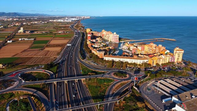 Aerial view of highway interchange and Port Saplaya coastline. Panoramic drone view of highway junction near Port Saplaya residential complex and Mediterranean sea coast in Alboraya.