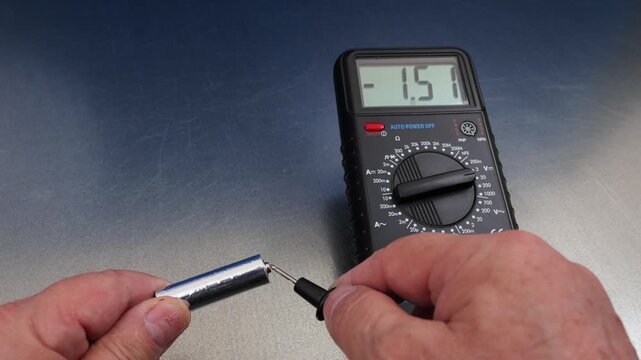 Measuring the voltage of alkaline batteries using a digital multimeter.