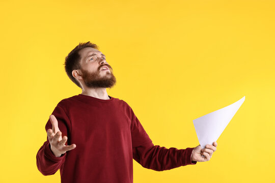 Professional actor with script performing on yellow background