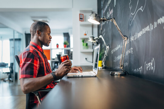 Focused freelancer working on laptop at modern office desk