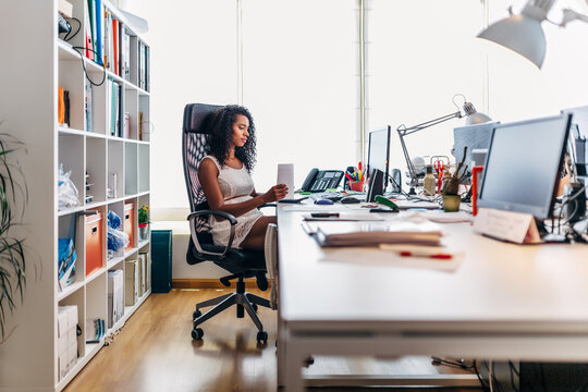 Professional woman reading on tablet in modern office