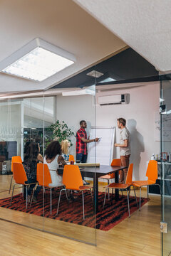 Team meeting in modern glass office with flip chart