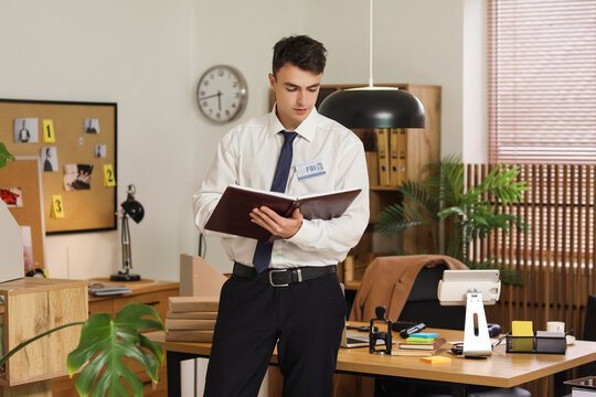 Male FBI agent with notebook in office